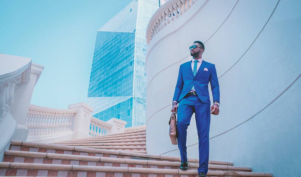 Businessman in a suit on building stairs looking confident
