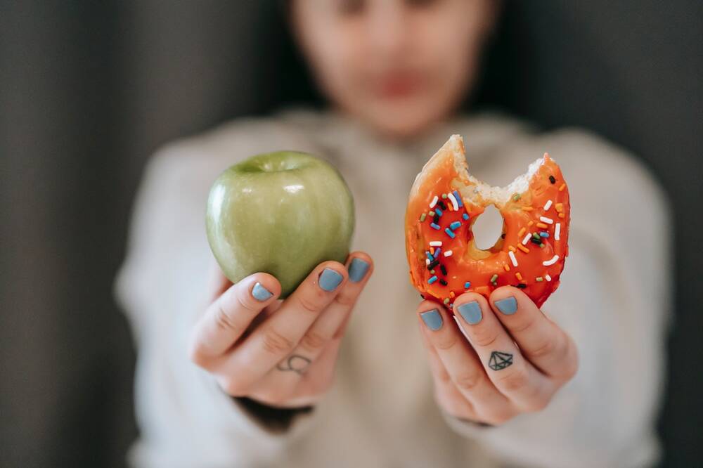 An apple and cookie held in two hands