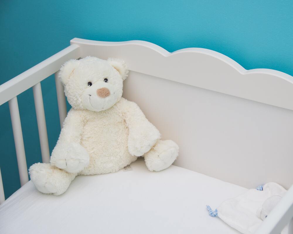 Baby crib with a teddy bear