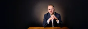 Jake Smolarek, a high-performance coach, with a focused and analytical expression, representing a CEO ready to diagnose and fix team underperformance.