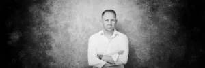 Jake Smolarek, a high-performance coach for leaders and high achievers, in a black and white portrait.