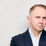 Jake Smolarek, a high-performance coach for leaders in London, in a business jacket for his definitive guide on growth mindset vs fixed mindset.