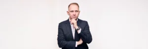 A professional portrait of Jake Smolarek, a high-performance coach in London, in a thoughtful, strategic pose.