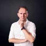 Jake Smolarek, team coaching expert, in a strategic thinking pose for his guide on building high-stakes teams.