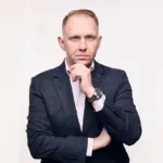 Jake Smolarek, business coach and high-performance strategist, in a formal portrait representing founder leadership and scalable systems.