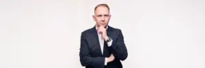 Jake Smolarek, business coach and high-performance strategist, in a formal portrait representing founder leadership and scalable systems.